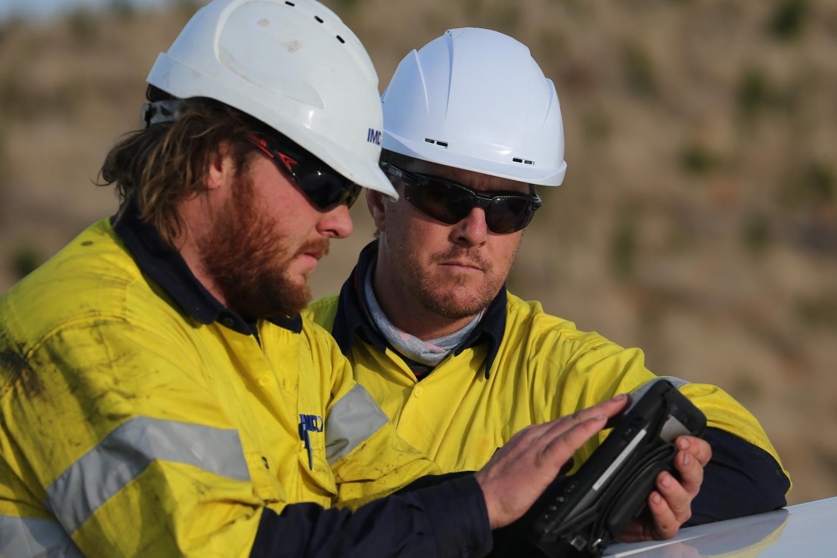 Drillers in the field, using IMDEXHUB-iQ and survey data on tablet